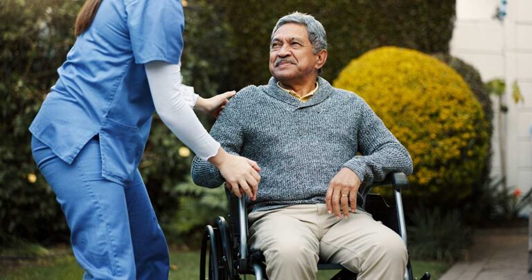 A group of older adults enjoying a picnic and light activities in a landscaped garden during spring.