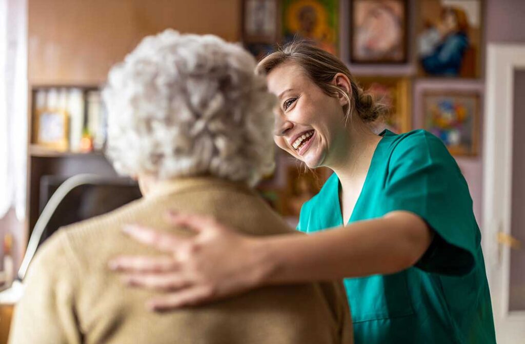 Family members visit an older adult in a bright assisted living common room.