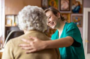 Family members visit an older adult in a bright assisted living common room.